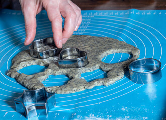 process of making cookies with poppy seeds: tin molds squeeze out the dough