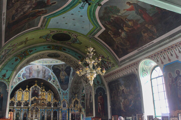 Interior decoration of the church. Painted walls of the temple. Chandelier
