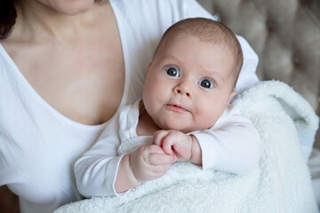 Portrait of a cute newborn happy baby on a white background, top view. The kid with the big eyes
