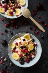 muesli with berries and milk on a dark board