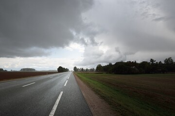 Empty highway (asphalt road) through the fields. Dramatic sky before the rain and thunderstorm....