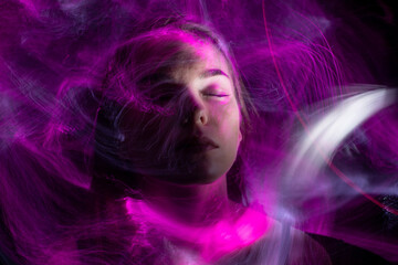 beautiful girl model with cosmic make-up on face, blue and purple color on dark background , longexposure foto