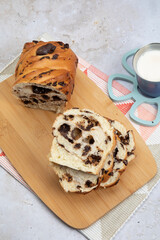 Delicious chopped chocolate bread on wood with a nutritious glass of milk on stone background