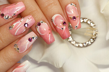 Light pink nail design with white lines, rhinestones, glitter with gladiolus.