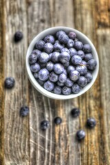 blueberries in a bowl on wooden table