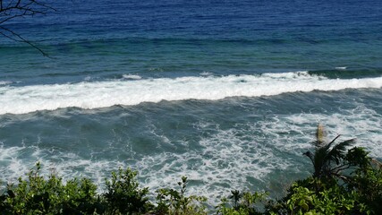 Gentle waves rolling toward a rocky shoreline in the southern part of the Philippines.