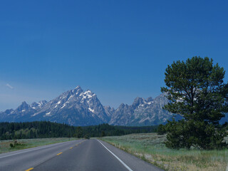 Naklejka premium Scenic drive with the Grand Teton Mountain ranges in the distance, Wyoming.