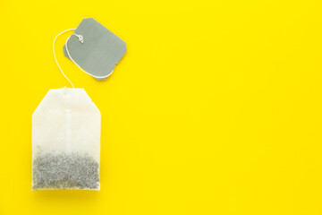 Tea bag with grey blank label on yellow background. Copy space for text.