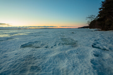 red mooring buoy and ice, snow structures on a frozen lake at sunrise in finland. scandinavian nature ук
