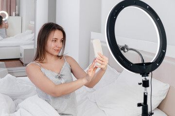 Female Blogger Recording Vlog Video on smartphone At Home Online Influencer On near bed. Streaming...