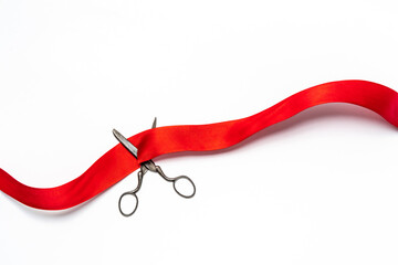 Studio shot of old fashioned scissors cutting red ribbon