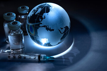 Glass globe with vials and syringe