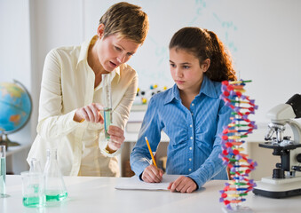 Teacher helping student in science lab