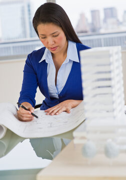 Female architect looking at blueprints