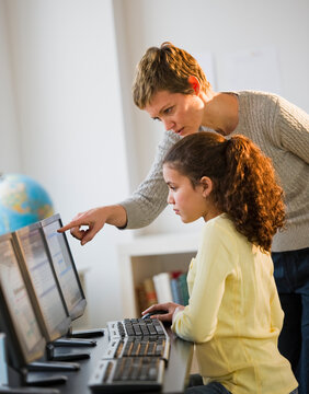 Teacher helping student in computer lab
