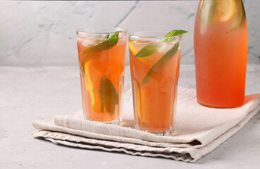 Healthy vitamin rhubarb and strawberry summer drink with mint, lemon and ice on a light gray table. Horizontal format, Space for text