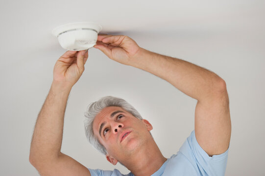 Man testing smoke detector