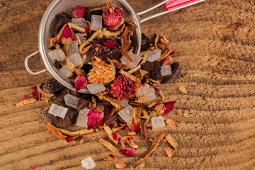 Fruit and herbal tea. Tea mixture on a rough wood background. Dried and specially processed plant material. Top view.