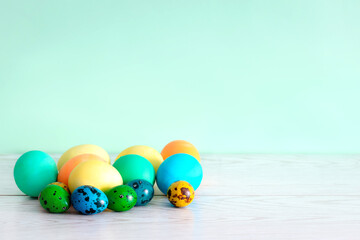 Easter painted colorful eggs on wooden desk, spring, easter concept on green background with copy space