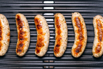 Delicious german sausages on the barbecue electro grill. Tasty sausages sizzling on a portable...