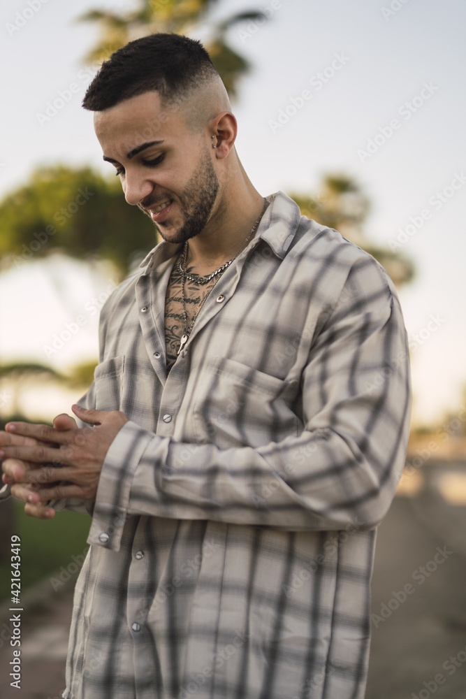 Sticker vertical shot of a handsome caucasian spanish man with tattoos posing outdoors