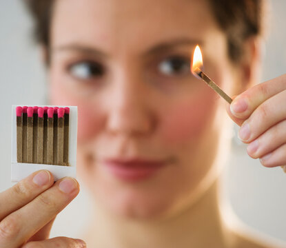 Young woman igniting match