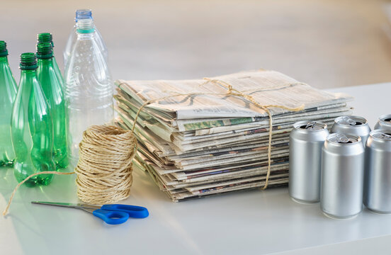 Recycling bottles, cans and newspapers with scissors and string