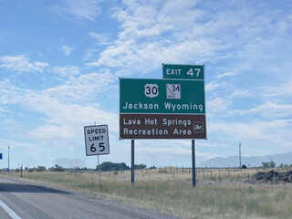 Sign along the road with directions to Jackson and Lava Hot Springs Recreation Area in Wyoming, USA.