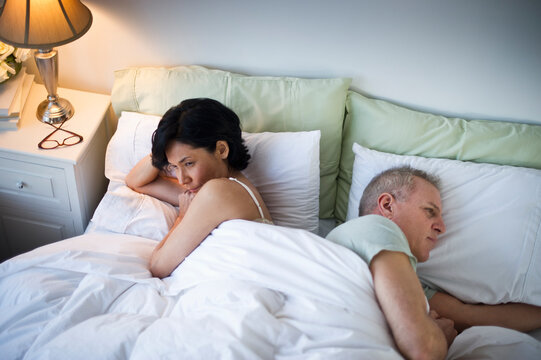 Mature couple laying in bed after argument