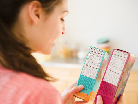 Woman Reading Nutrition Facts On Food Packaging