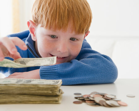 Portrait of boy (8-9) counting money