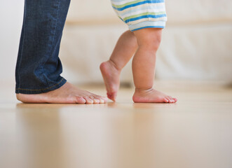 Mother assisting in her son's (6-11 months) first steps