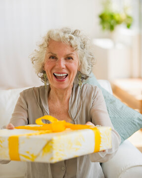 Surprised woman receiving a birthday gift