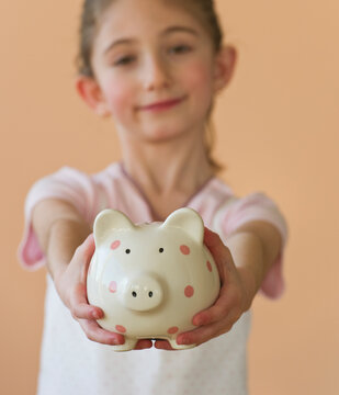 Young girl holding a piggy bank