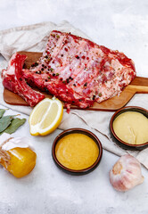 Raw pork ribs, fresh meat with mustard sauce and lemon, top view, flat lay, copy space