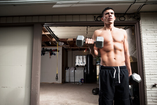 USA, Seattle, Muscular man training with dumbbells