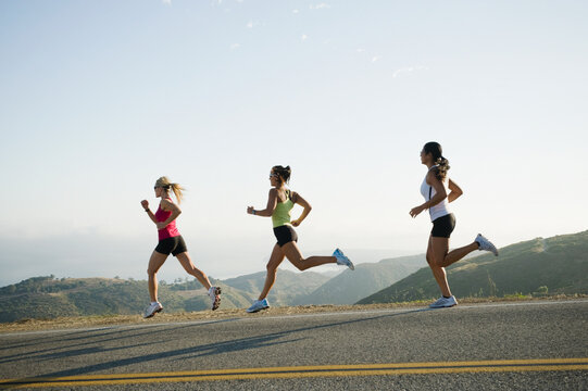 Runners training on side of a road