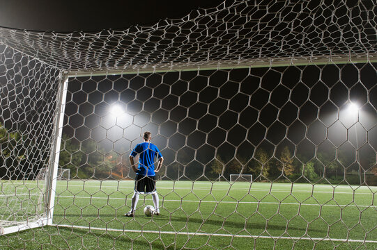 USA, California, Ladera Ranch, goalie on illuminated soccer field at night