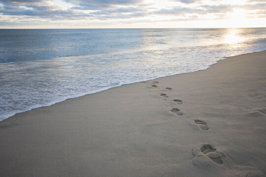 USA, Massachusetts, Cape Cod, footprints on beach at sunset