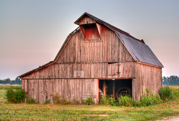 Obraz premium Glowing pink barn at sunset