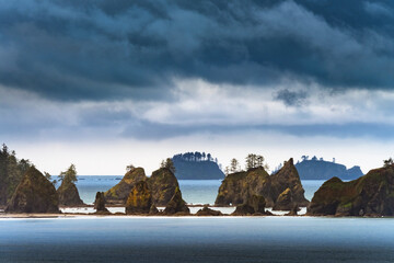 Fototapeta na wymiar USA, Washington State, Olympic Peninsula. Light breaks through clouds Point of the Arches.