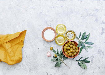 Top view organic olive oil, olives, fresh toast bread and olive branch on white background, space...