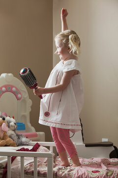 Young girl dancing on her bed