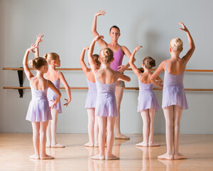 Female instructor training ballet dancers (6-8) in dance studio