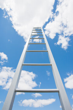 Ladder reaching cloudy sky