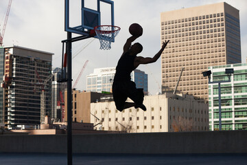 USA, Utah, Salt Lake City, Silhouette of young man playing basketball