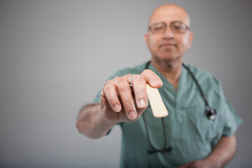 Doctor holding a tongue depressor