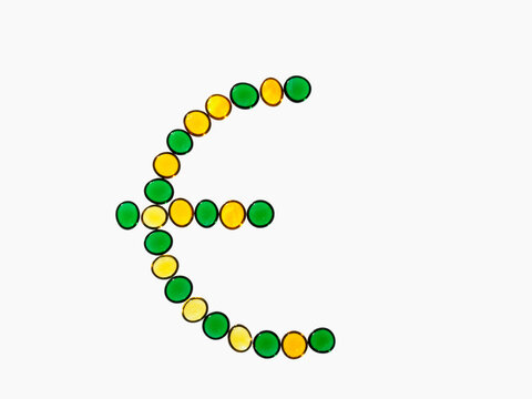 Studio shot of yellow and green glass beads in euro symbol shape