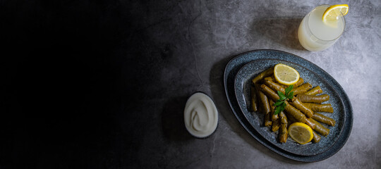 Top view, Plate with delicious, stuffed grape leaves with parsley and lemons called Dolma , made from vines with rice, meat and spices.