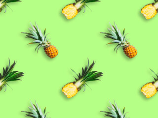 Seamless pattern of ripe pineapples isolated on green background. Top view. Exotic tropical fruit summer concept